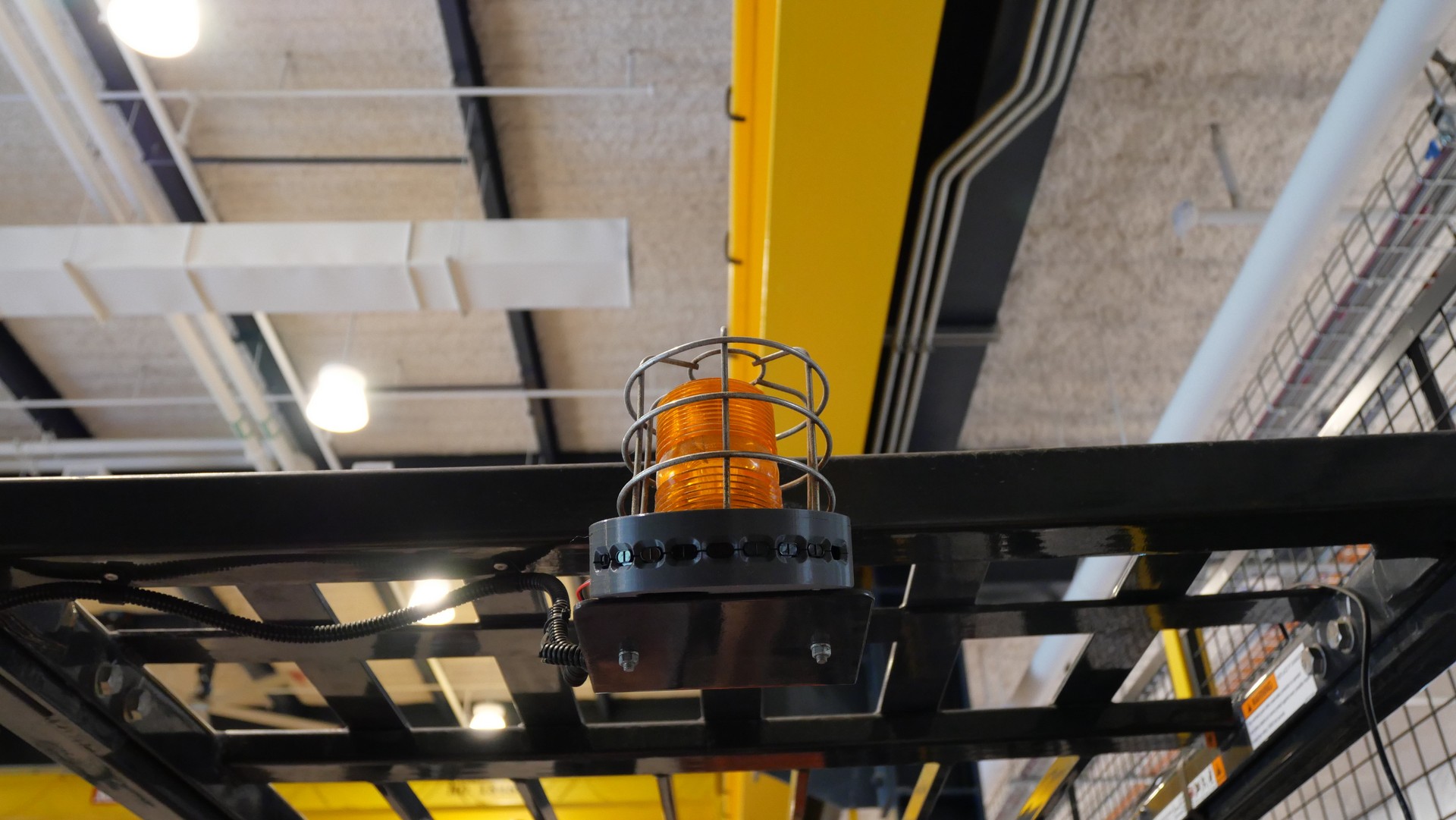 Amber warning beacon and proximity sensor assembly mounted above a forklift operator area